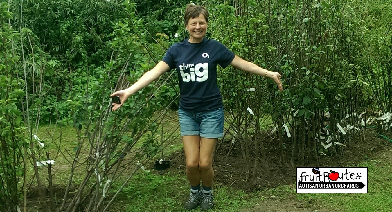 An O2 CSR team member proudly shows her the neat edging at the Lyndale Orchard